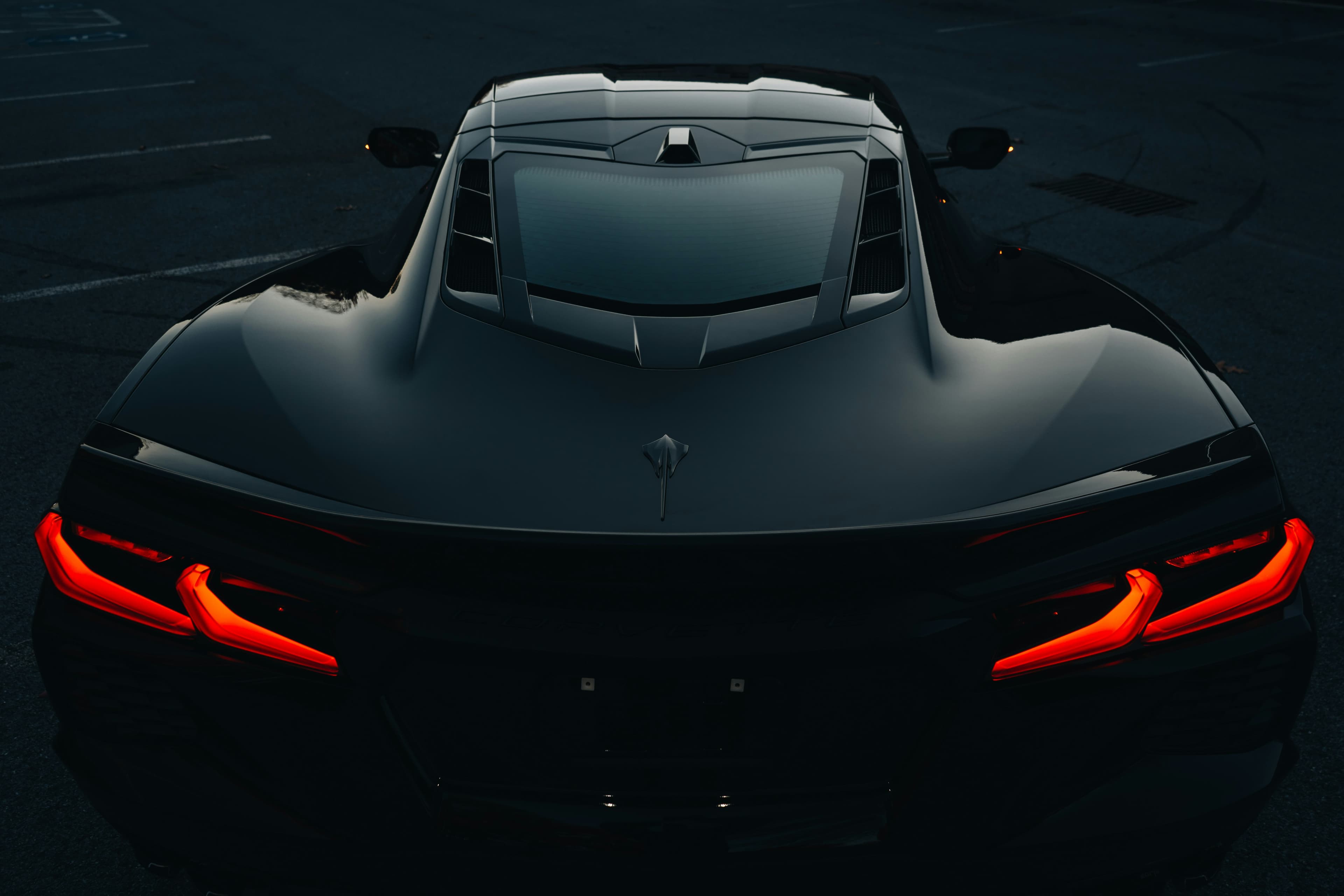 Traseira de um Chevrolet Corvette C8 preto com as lanternas vermelhas acesas